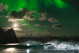Mick Fanning surfs a wave under the Northern Lights in Norway.