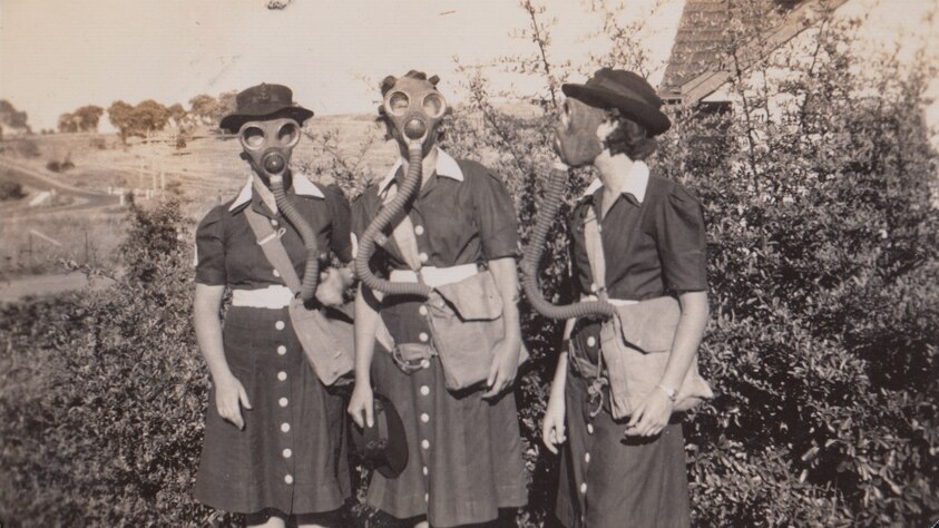 Three Women's Royal Australian Naval Service personnel wearing gas masks.