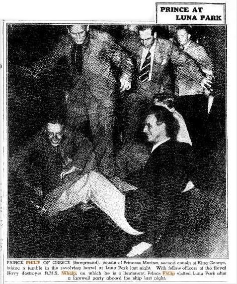 A black and white clipping showing a group of laughing people milling around a man laughing on the ground