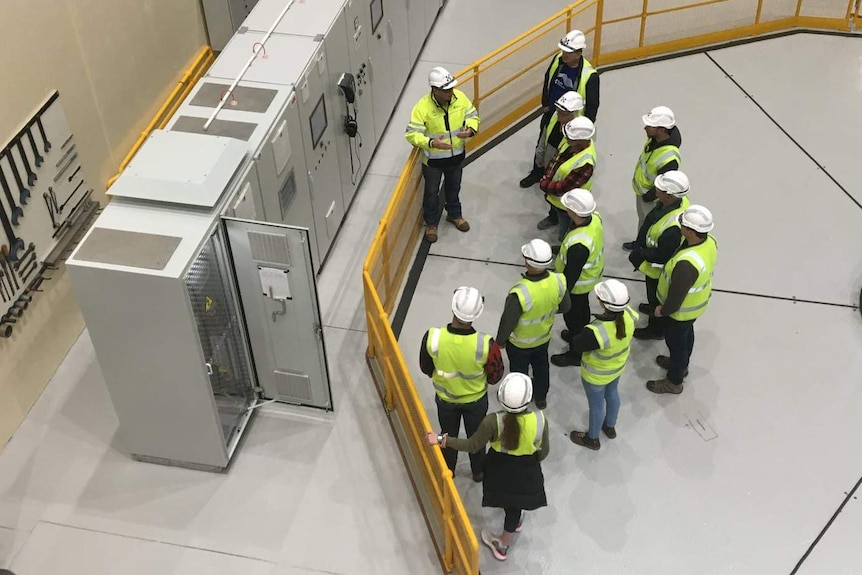 A birds eye view of a group of workers wearing high visibility clothing and hard hats.