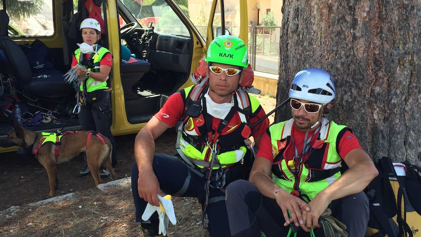 Rescue workers with sniffer dogs.