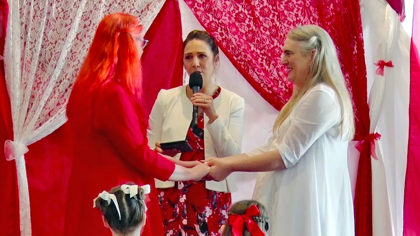 Transgender lesbian couple in their sixties getting married with red and white colour theme