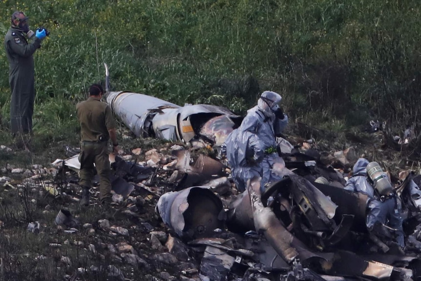 Israeli security forces examine the remains of the F-16 Israeli warplane.