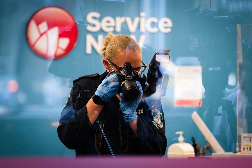 Police officer with camera at Service NSW site