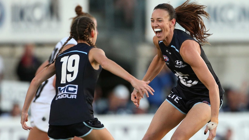 Alison Downie and Georgie Gee celebrate a goal for Carlton against Collingwood