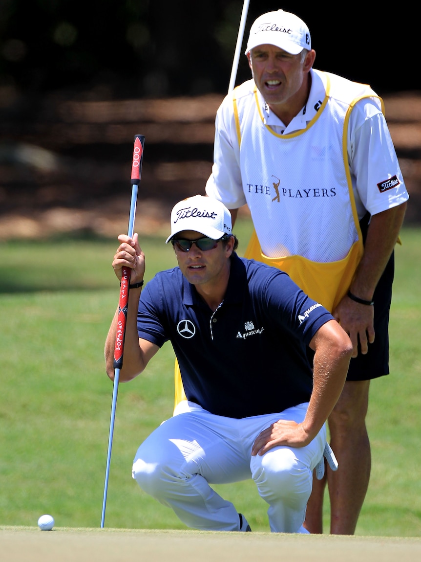 Adam Scott lines up his putt before birdieing the second at TPC Sawgrass.