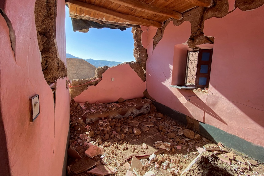 A house with pink walls has rubble all over the floor.