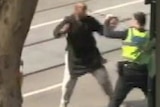 Video still of suspect attempting to stab a police officer
