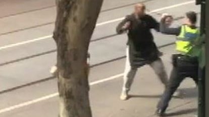 Video still of suspect attempting to stab a police officer