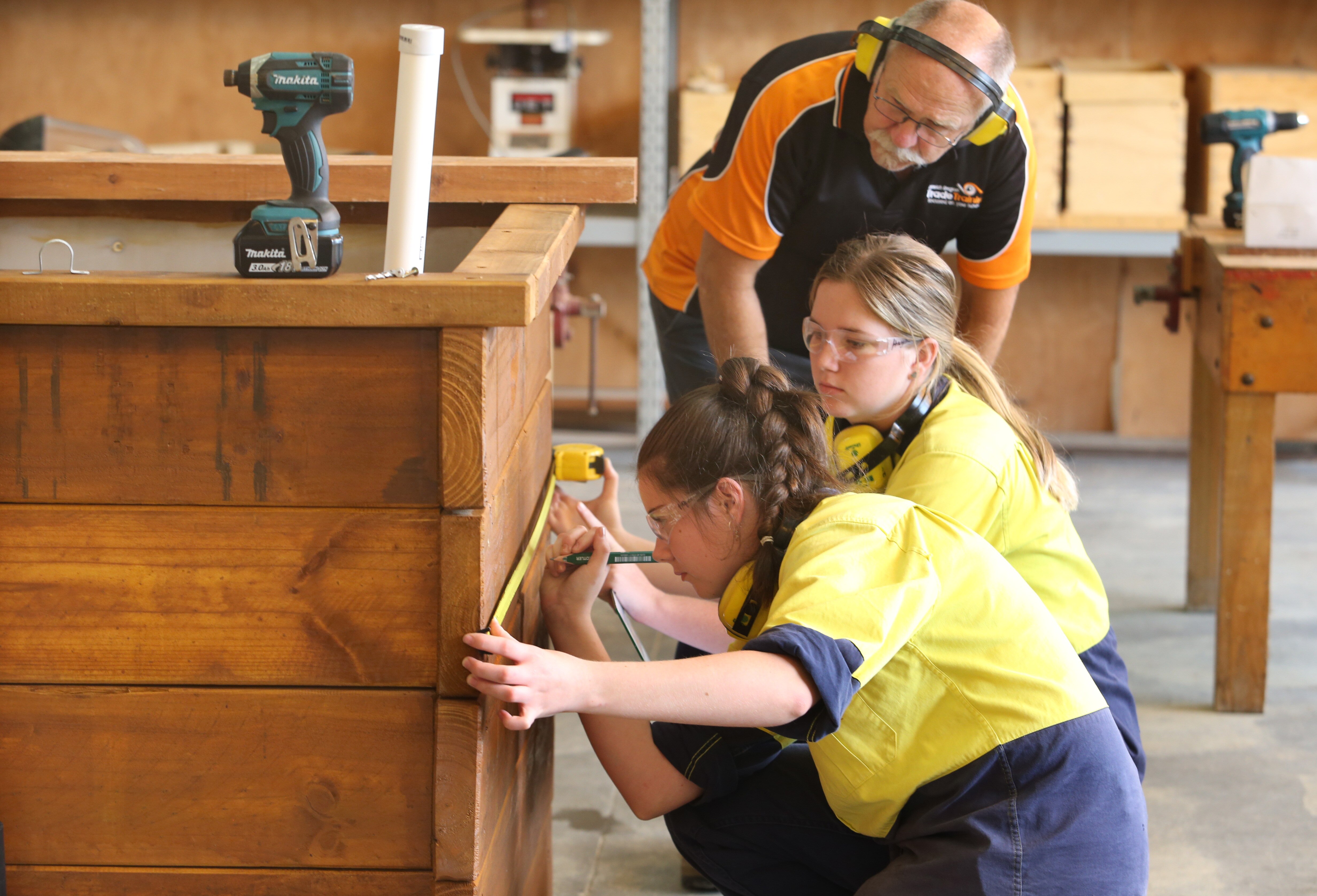 Girls measure dimensions of planter box