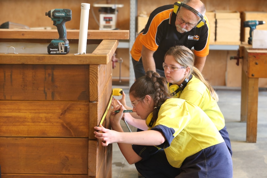 Girls measure dimensions of planter box