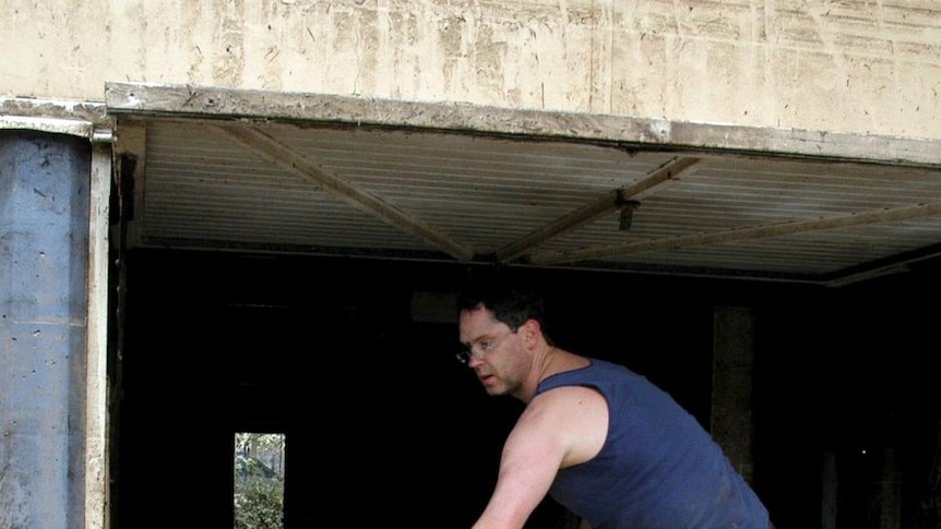 Sweeping and hosing: Peter Carey helps clean a home in Sherwood