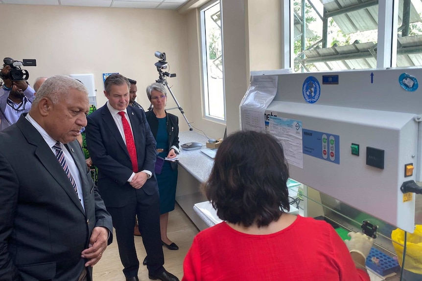 Frank Bainimarama inspects testing equipment for coronavirus, at a recently opened laboratory.