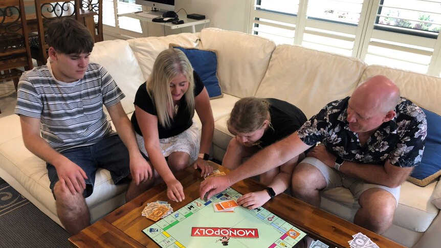 Nicole Forbes-Hood, her husband and two children play Monopoly.