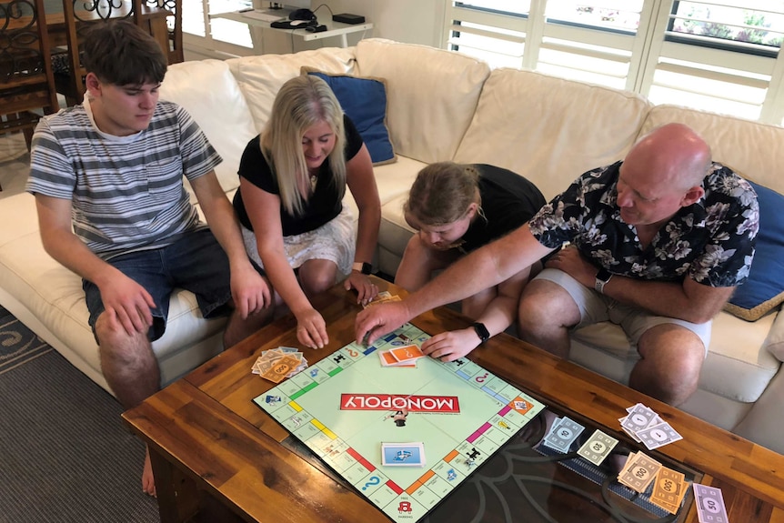 Nicole Forbes-Hood, her husband and two children play Monopoly.