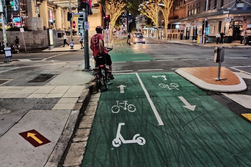 A separated bike lane through Brisbane CBD with an e-scooter stencil on the green paint
