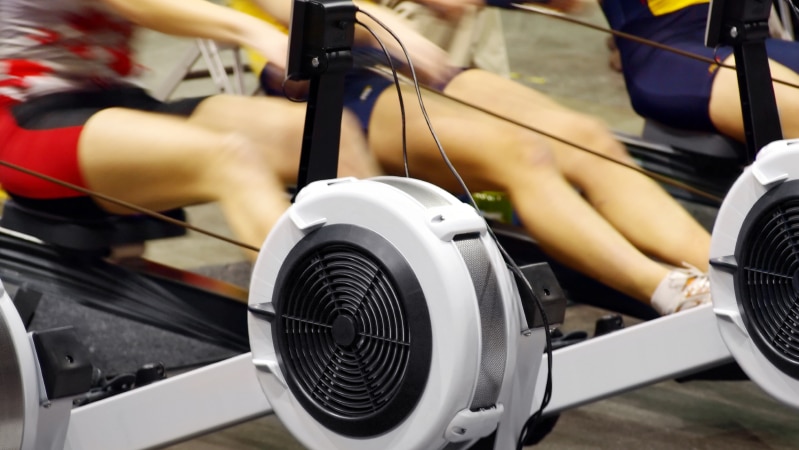 Three women at the gym working out on rowing machines