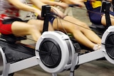 Three women at the gym working out on rowing machines