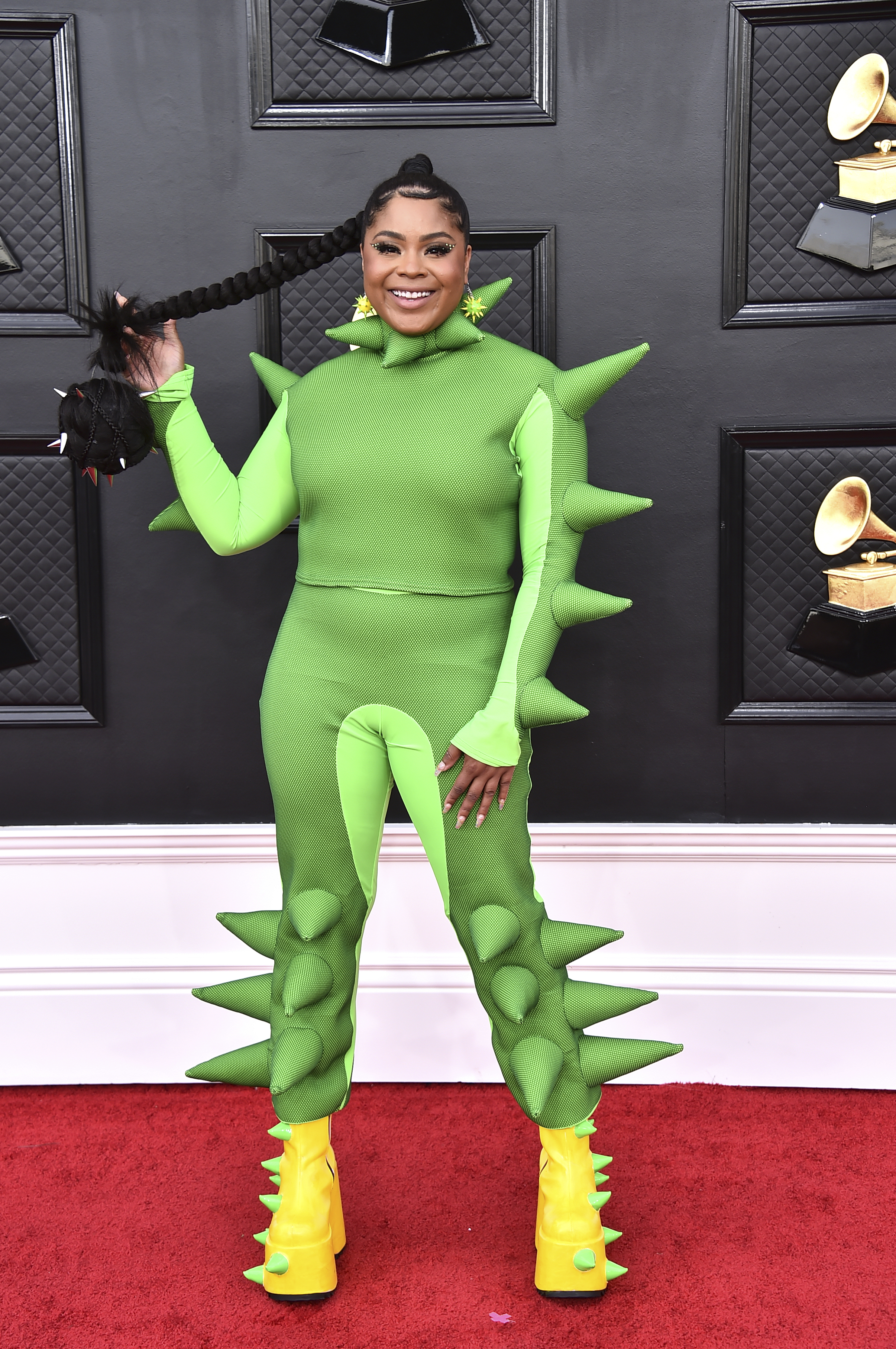 songwriter tayla parx wears a bright green bodysuit with dinosaur spikes on the grammys red carpet