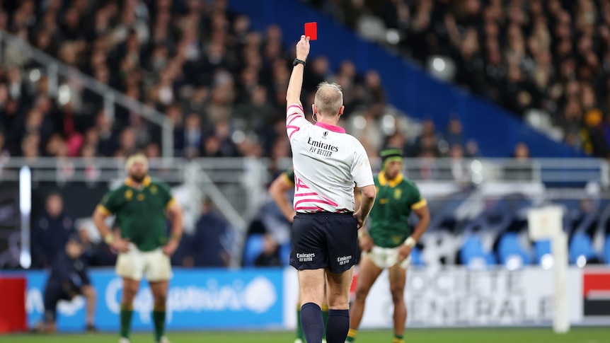 Referee Wayne Barnes holds up a red card for All Blacks captain Sam Cane during the Rugby World Cup final.