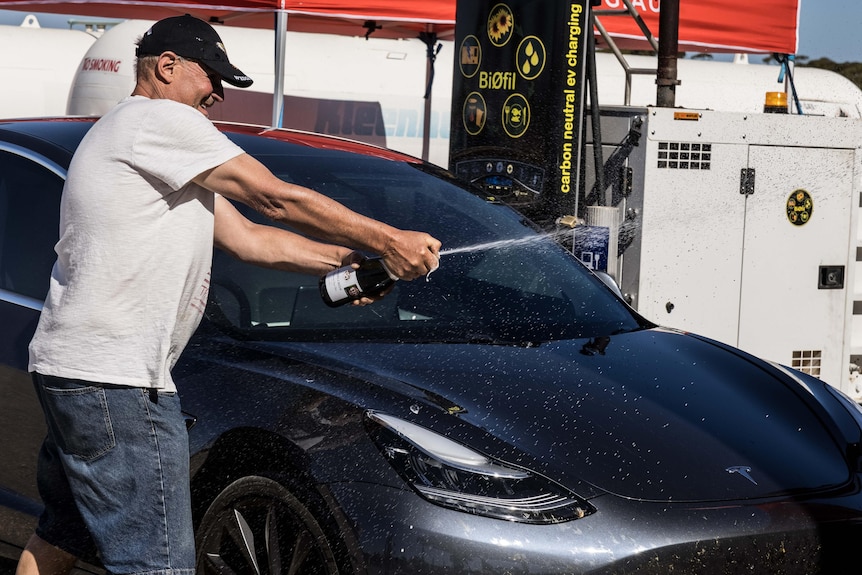 A man pops a bottle of champagne. 