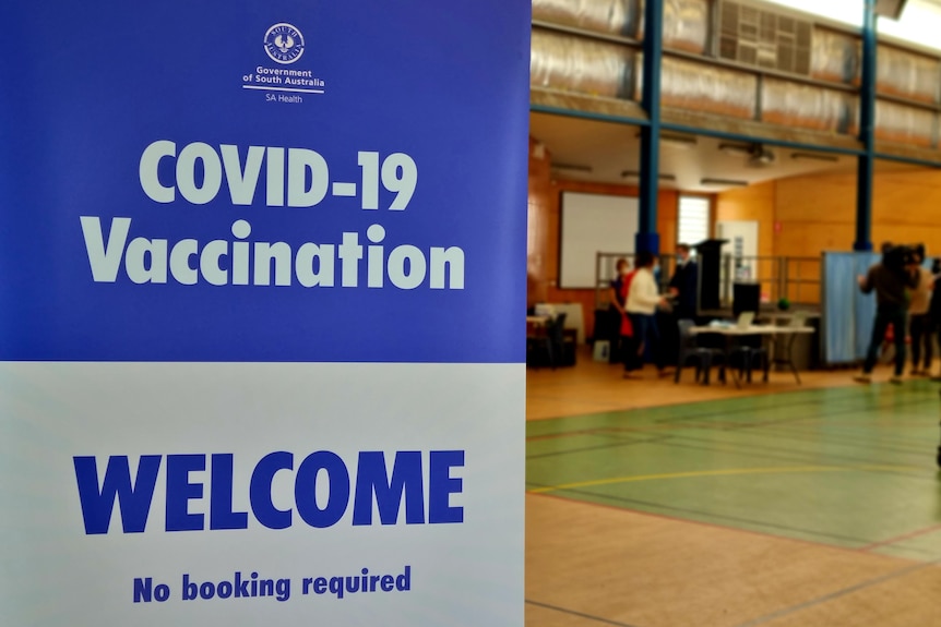 A sign for a vaccine clinic in a school gym
