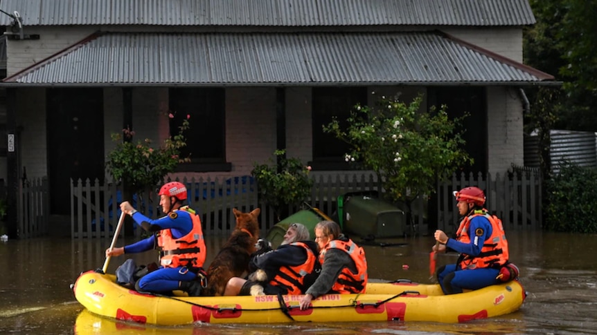 A bright rescue boat carries Lismore residents to safety as floodwaters rise