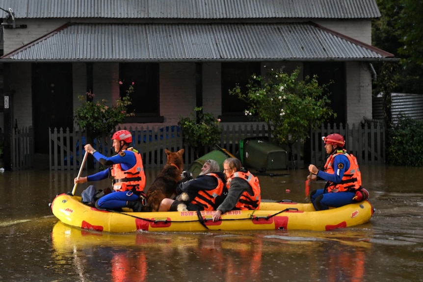 A bright rescue boat carries Lismore residents to safety as floodwaters rise.