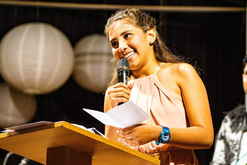 Young girl holding microphone on stage