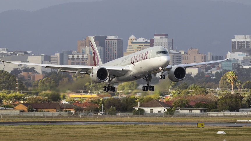 plan landing on tarmac with wheel down and cityscape in the background