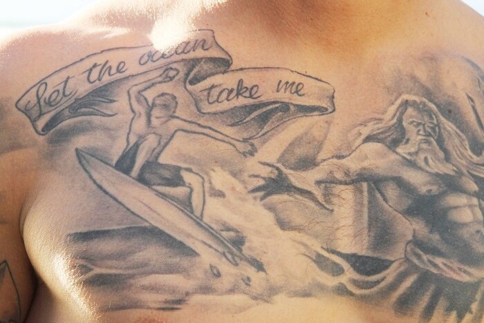 A tattoo of a surfer on a mans chest
