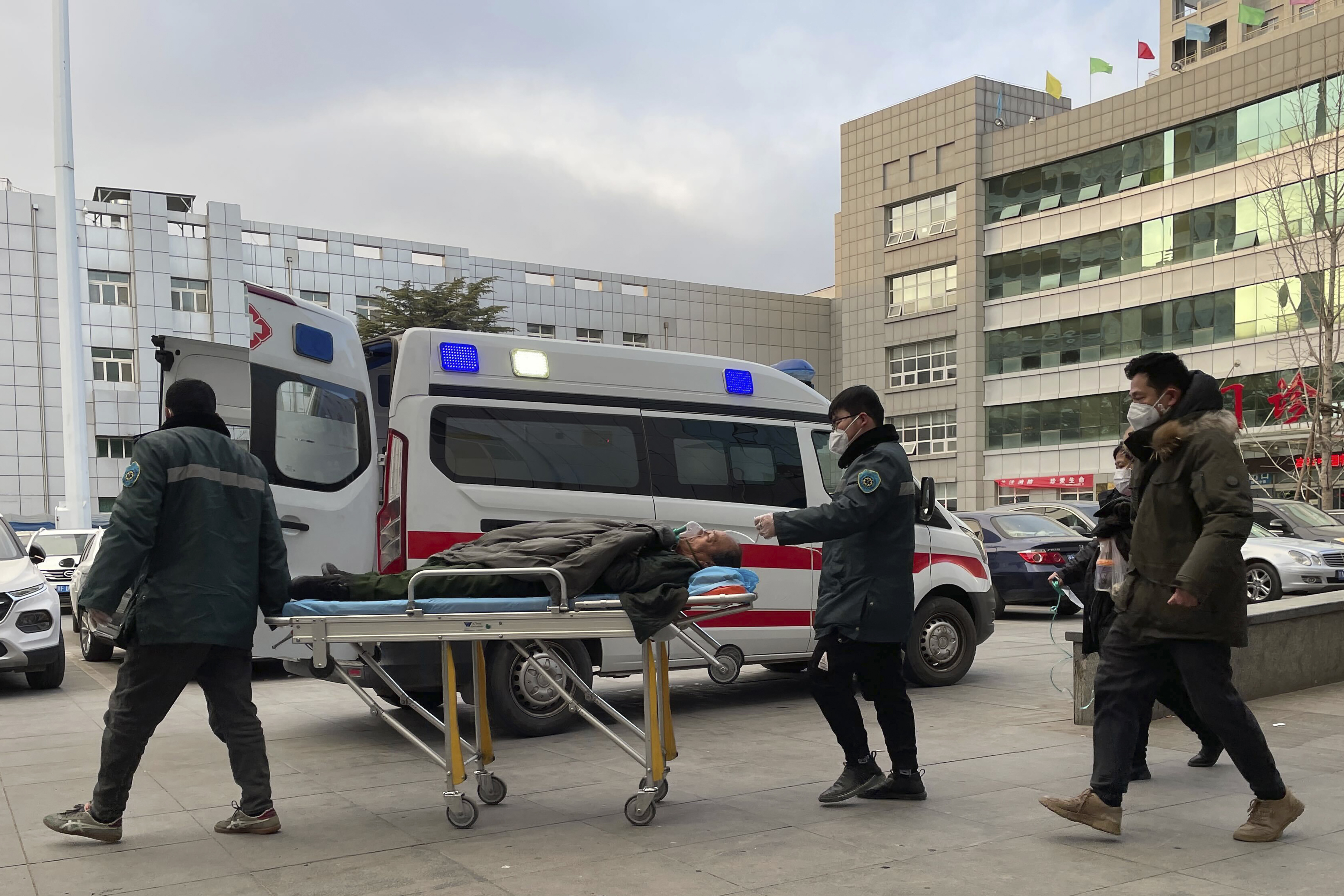 医务人员将一名男子推过医院外的救护车。 “ class=