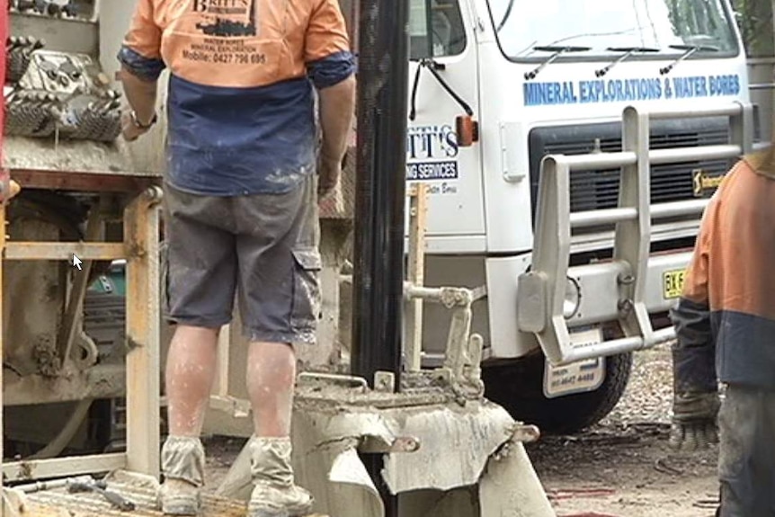 Men work around a bore drill