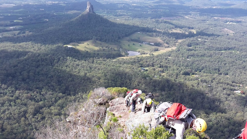 Queensland Fire rescuers climb a trail on Mt Beerwah, in the Glasshouse Mountains