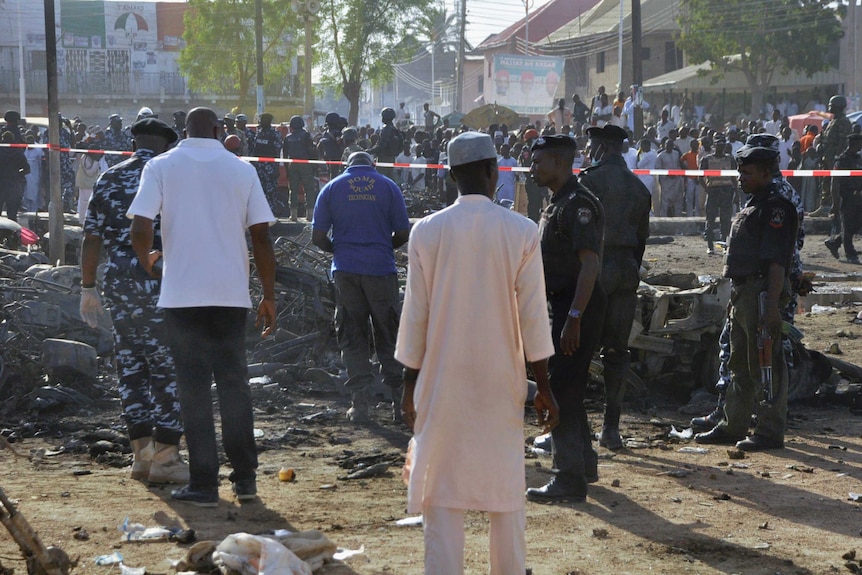 Bomb squad experts and security personnel inspecting bike wreckages at a scene of multiple bombings at the Kano Central Mosque November 28, 2014.