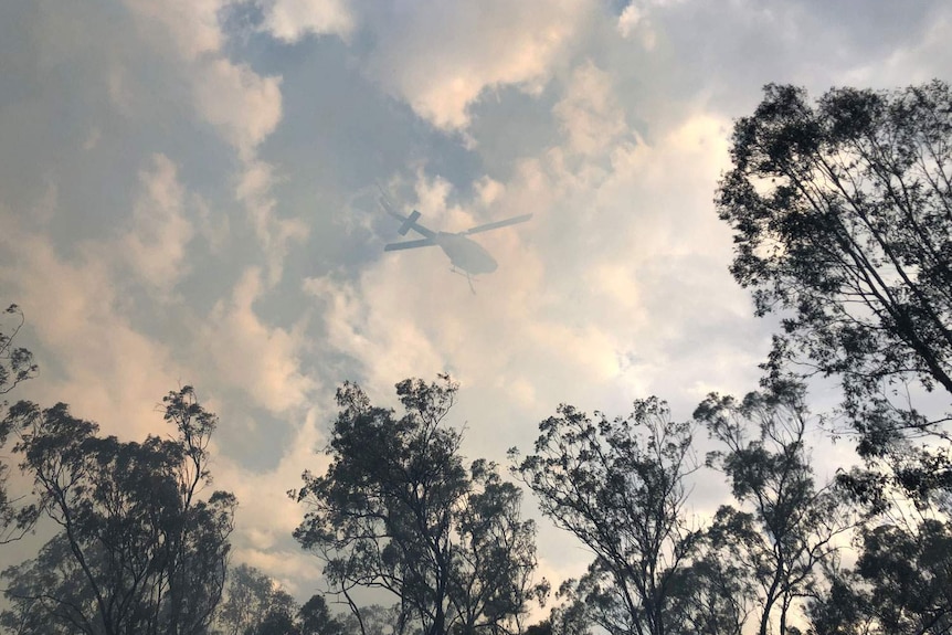 Smoke shadows helicopter waterbombing bushfire at Laidley