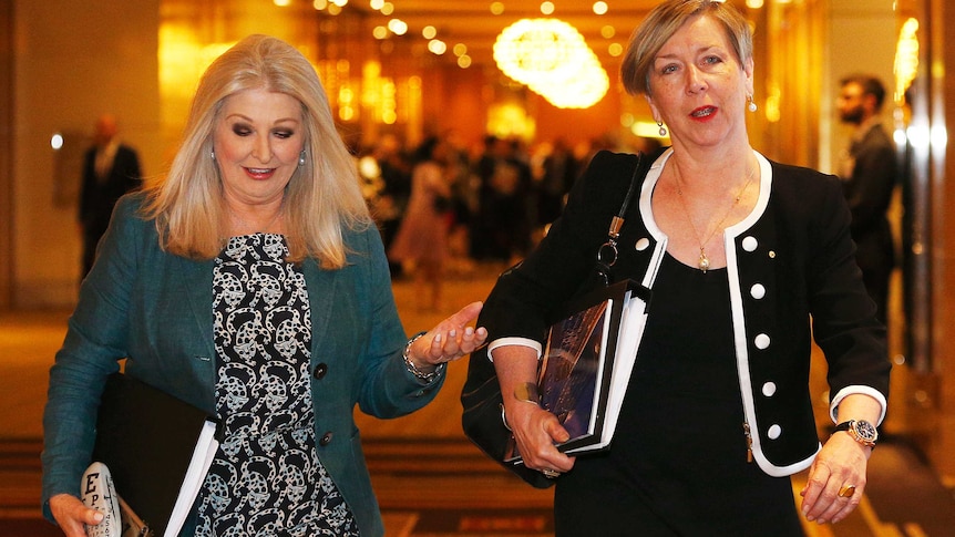 Two women walking through a lobby