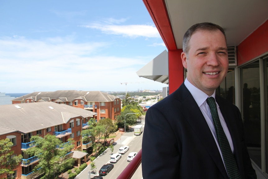 A man in a suit smiling.