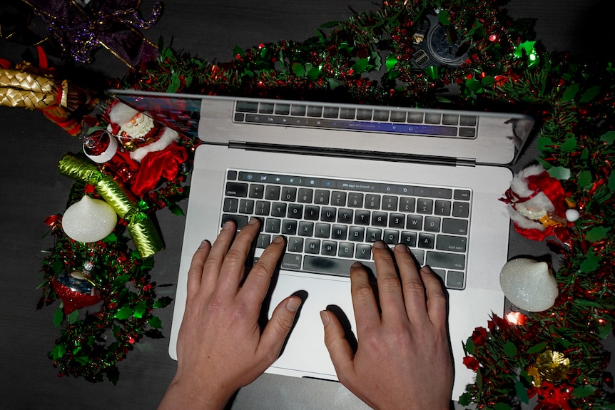 A computer surrounded by Christmas decorations