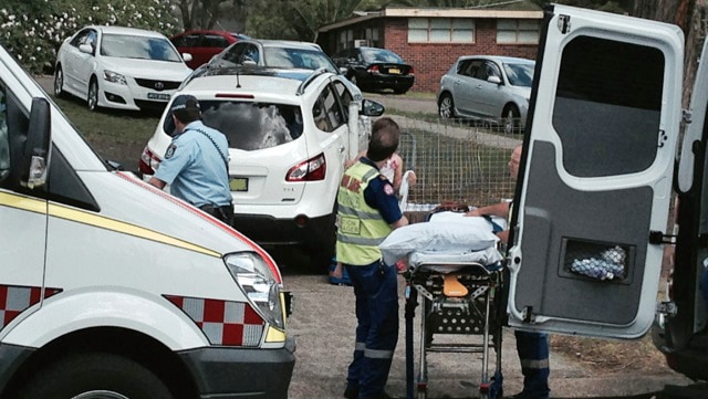 Paramedics attend to injured people at the scene of a fatal crash