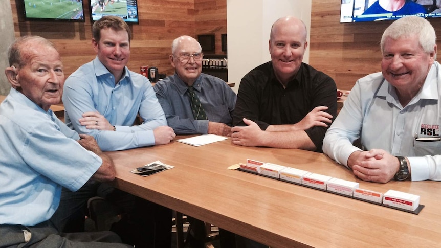 A group of men sit together in a bar