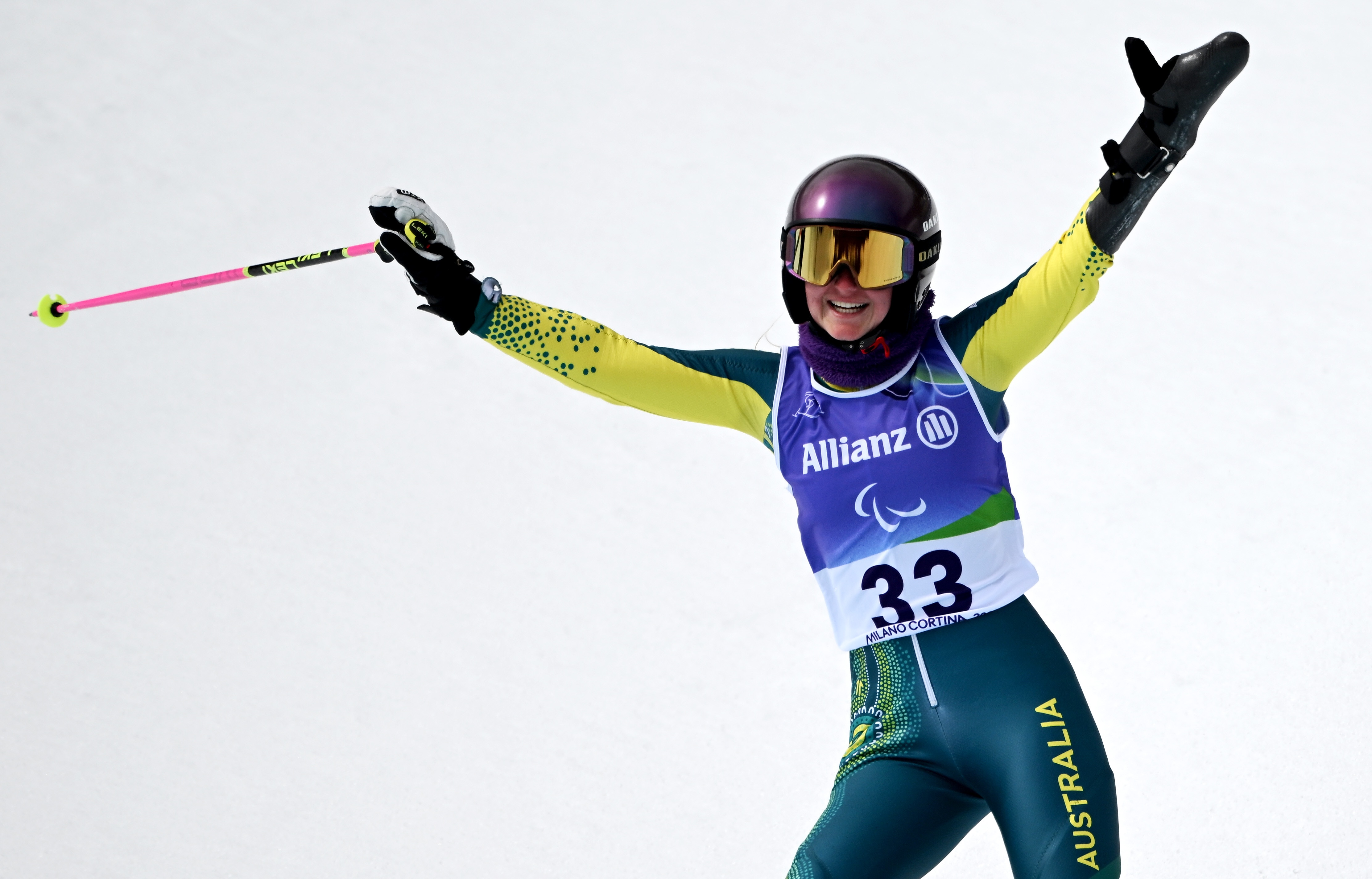Uma esquiadora para-alpina australiana sorri e balança seu esqui depois de completar uma corrida gigante de slalom nas Paraolimpíadas de Inverno.
