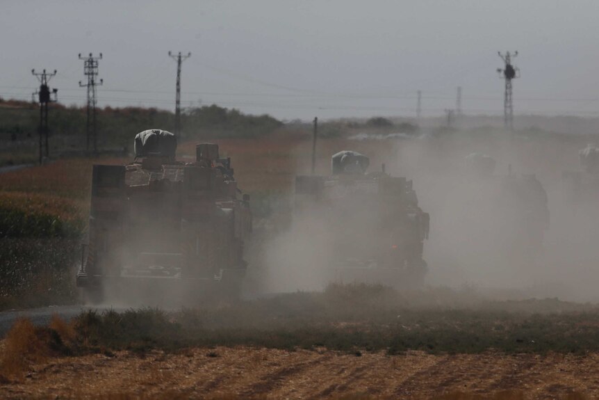 A convoy of Turkish forces' trucks transporting tanks is driven towards the border with Syria.
