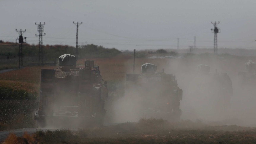 A convoy of Turkish forces' trucks transporting tanks is driven towards the border with Syria.