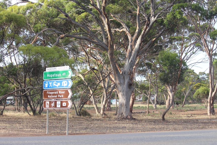 A sign to Hopetoun is pictured next to towering gums