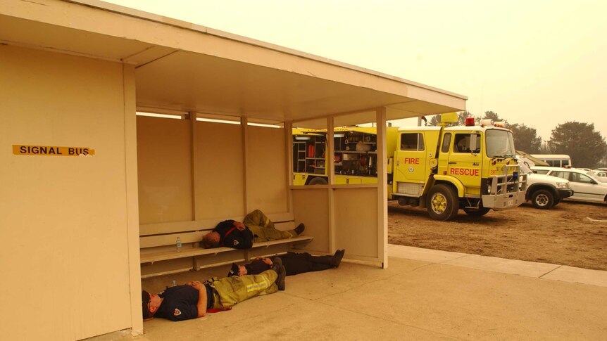Firefighters having a rest at a bus stop in Duffy.