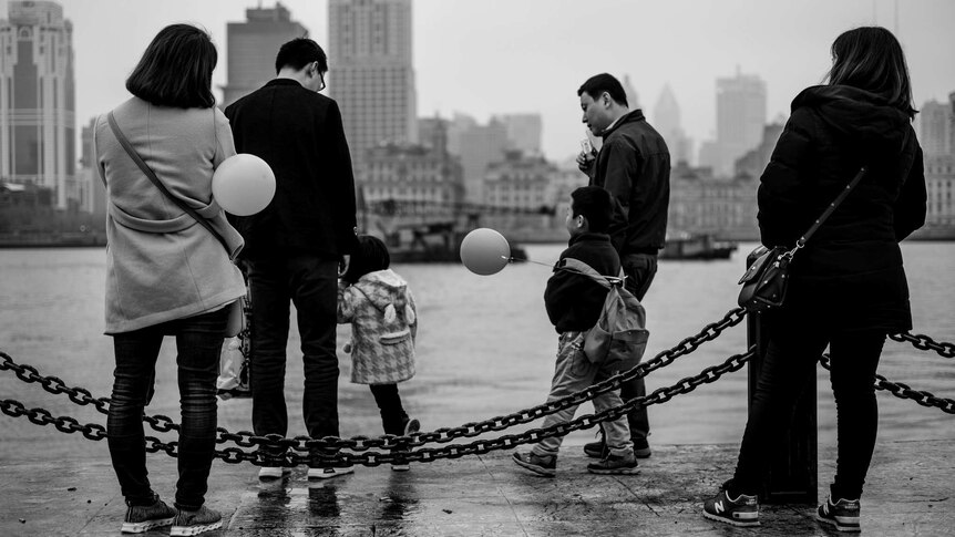 A family with balloons go for a walk