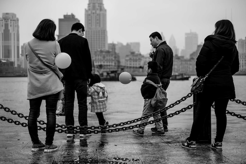 A family with balloons go for a walk