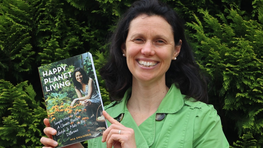 Canberra author Mia Swainson holding a copy of her book 'Happy Planet Living'