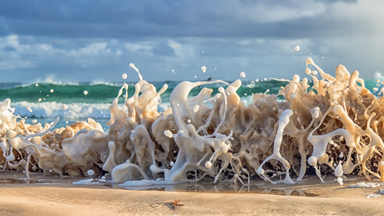 Close up of surf foam hitting beach